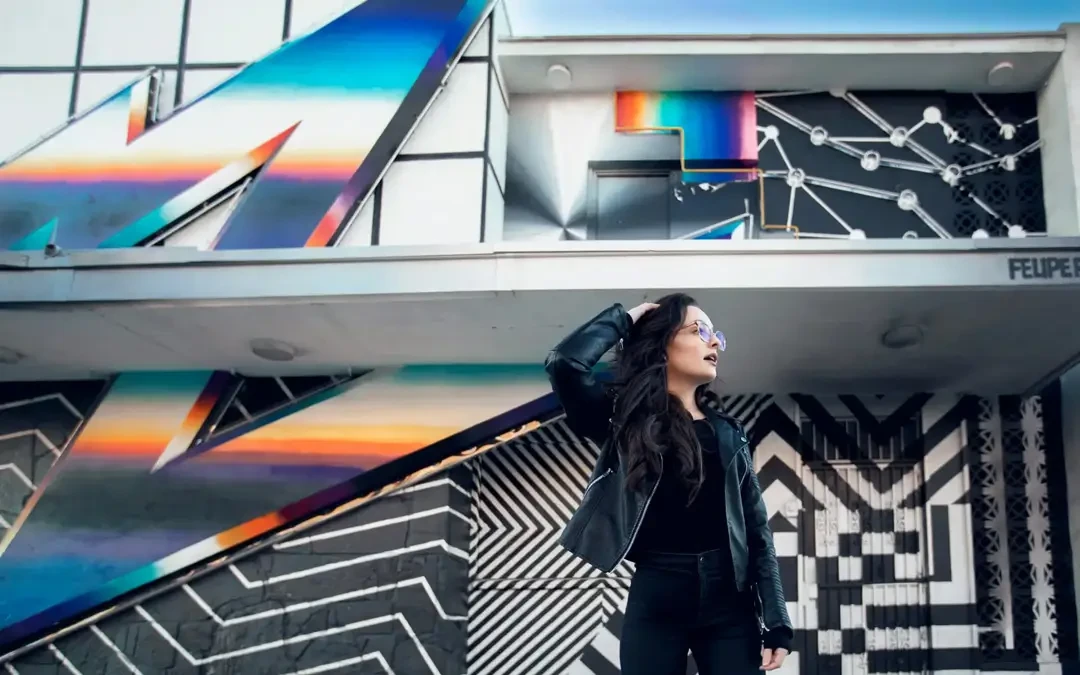 A young Gen Z woman in front of a brightly coloured mural