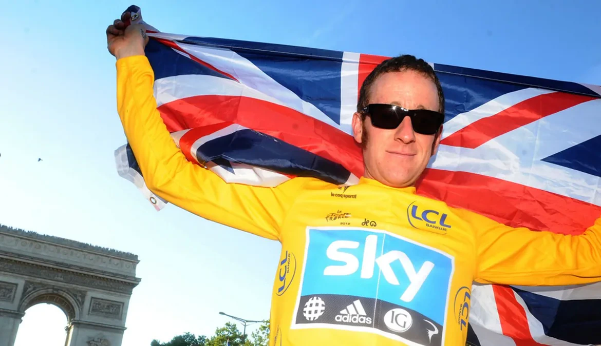 Bradley Wiggins in the 2012 Tour de France yellow jersey, holding a Union flag aloft beside the Arc de Triomphe