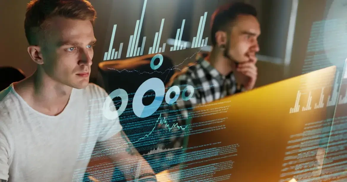 Two people working at computers with digital graphs and data overlays.